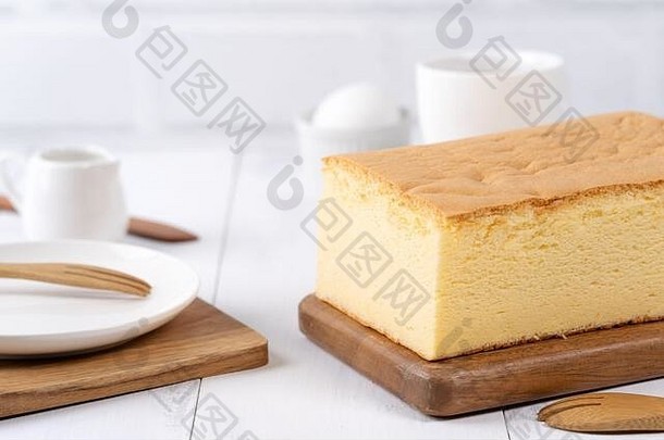 原汁原味的经典台湾传统海绵蛋糕（台湾castella kasutera）放在木制托盘背景桌上，配以配料，特写。