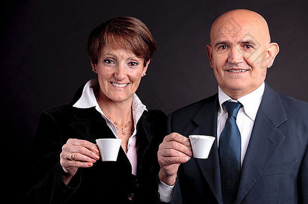 一对微笑的老夫妇举起两杯意大利espreso咖啡，面带微笑