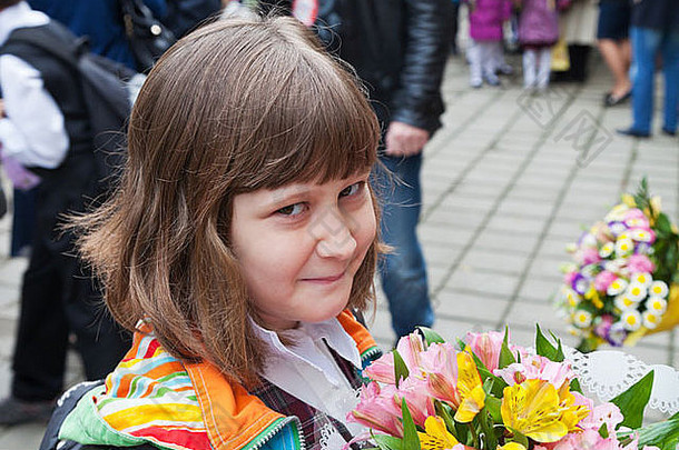 秋天，一个女学生带着一束花去上小学