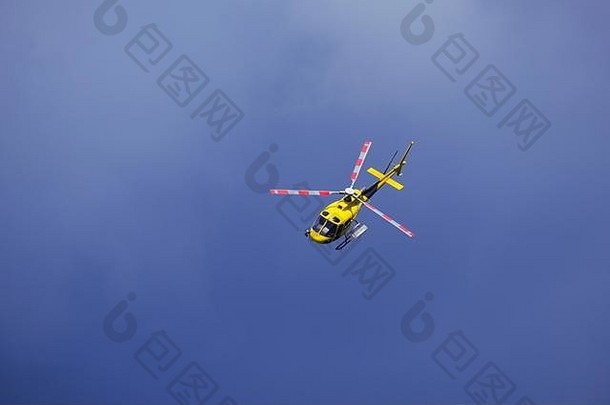 黄色的直升机孤立地在空中飞行。具有空间的戏剧背景