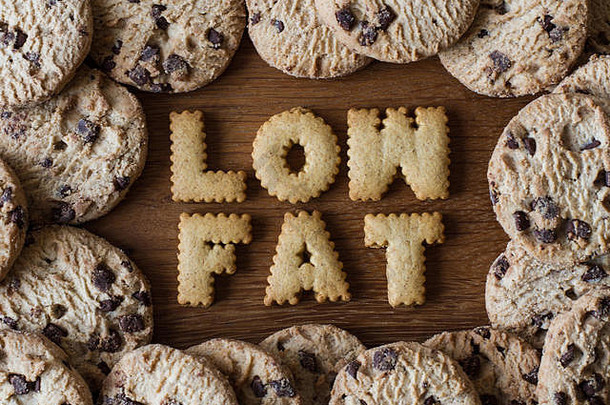 食物建议“低脂肪的拼写字母形状的饼干和包围谷蛋白免费的巧克力芯片饼干木背景
