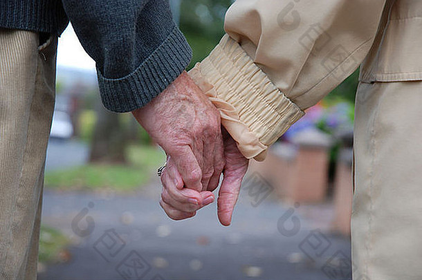 一个年长的男人和女人的手握在一起的特写镜头