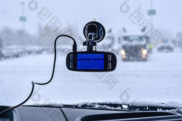 在前挡风玻璃上的汽车行车记录仪，记录前方的交通情况