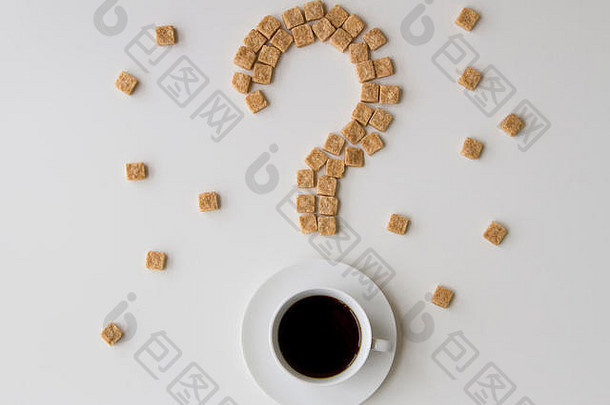 形状像问号的方糖和一杯白色背景的咖啡。顶视图。饮食不健康甜食成瘾概念