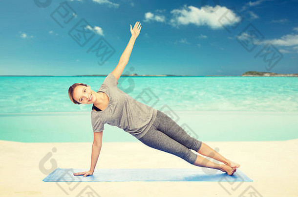 在海滩上做侧板式瑜伽的女人