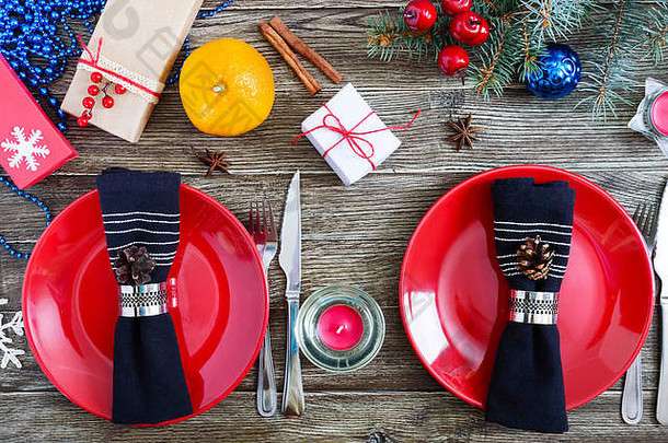 圣诞节表格设置红色的板叉刀橘子蜡烛餐巾礼物分支圣诞节树木背景圣诞节圣诞节