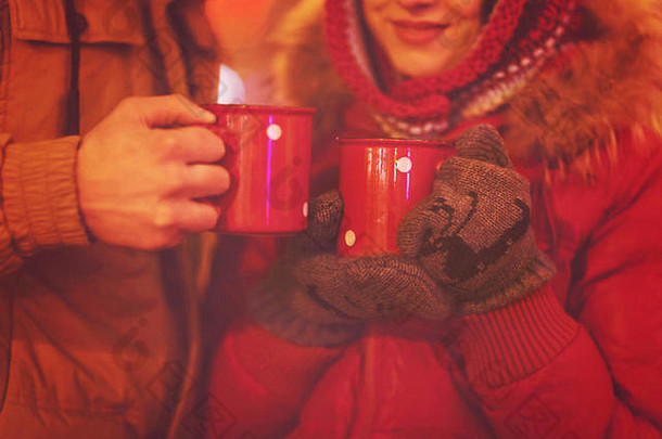 幸福的年轻夫妇在模糊的灯光下喝茶。闭合