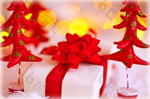 可爱的<strong>小礼品</strong>盒，用白纸包着，蝴蝶结上有红色的塑料杉树，时尚的圣诞静物