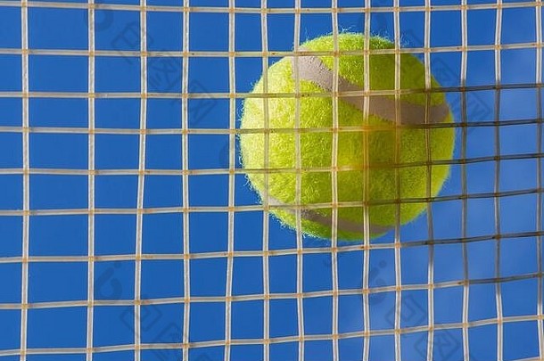黄色的网球球休息字符串网球球拍查看蓝色的天空