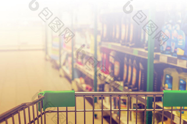 从购物车到抽象模糊超市过道背景的视图，白调用于复制空间。复古色调
