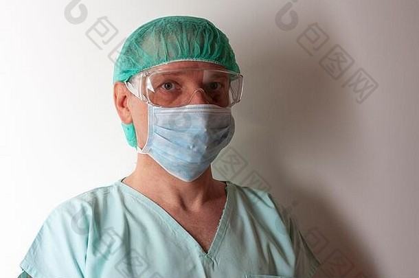 男护士，带2019冠状病毒疾病防护帽，戴有个人防护设备，用于保护ICU的病毒