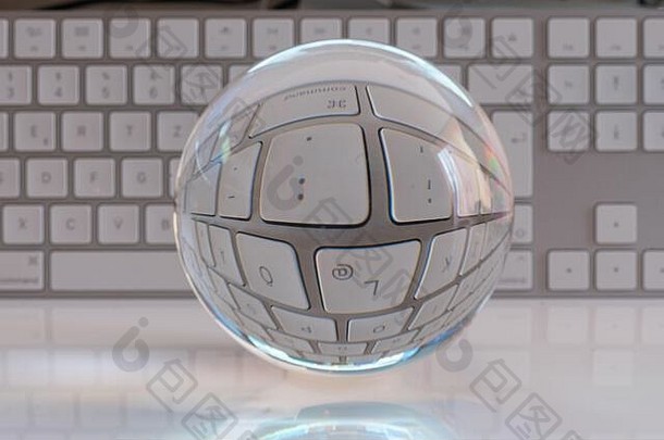 清澈的玻璃球站前面白色电脑键盘绚烂地照亮