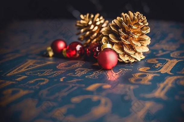 圣诞老人金色松木圆锥形和红色玻璃球装饰，复古式图案桌面背景。带复印空间的节日贺卡