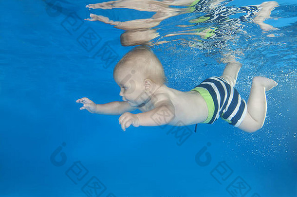5个月大的在游泳池里的水下游泳课上学习水下游泳