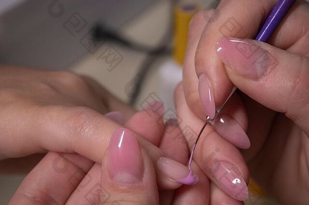 修指甲的过程。专业美甲师手部特写，涂指甲油。修指甲和指甲清洁的概念。美的概念。虫胶凝胶上光剂