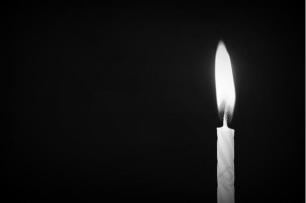 黑暗背景特写下的生日蜡烛。非黑即白的