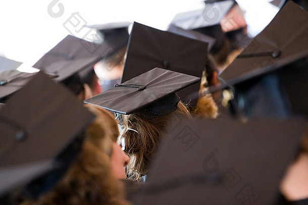 一群戴着传统帽子和长袍的大学或高中毕业生。浅景深。