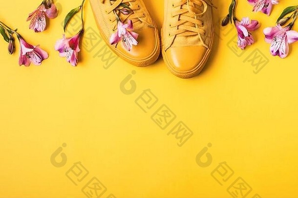 一对黄色的运动鞋花味蕾黄色的背景春天夏天时尚概念