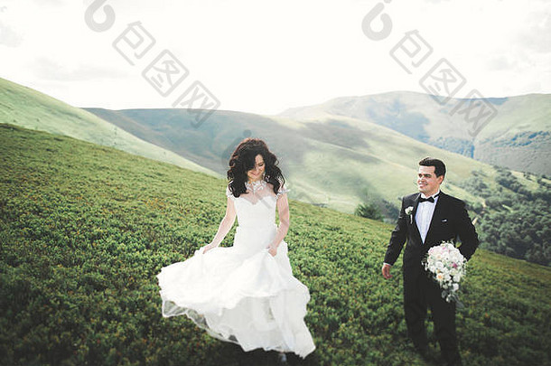 美丽的令人难以置信的快乐新娘时尚的新郎摆姿势背景阳光明媚的惊人的山
