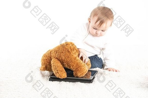 股票工作室照片白色背景婴儿玩平板电脑泰迪熊