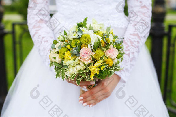 美丽的绿色婚礼花束新娘的手特写镜头
