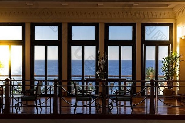大厅有五扇大窗户，可以看到海景。明亮宽敞的老式房间，木质窗户。阳光普照着俯瞰大海的房间