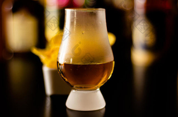 聚会时间，酒吧背景上有一杯威士忌、冰块和<strong>咸点心</strong>