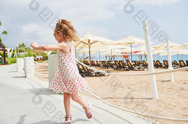 夏天，在海边的海滩上，一个穿着连衣裙的快乐。