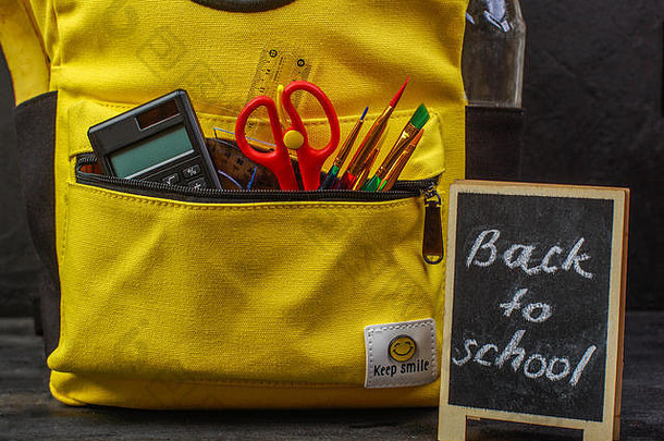 黄色学校背包，黑色背景配附件