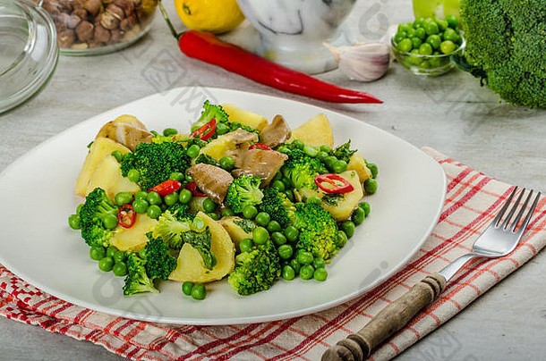 健康猪肉切痂配超级绿色蔬菜、花椰菜、豌豆、猪肉和土豆