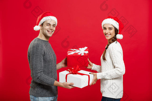 圣诞节概念-年轻迷人的情侣在圣诞节互送礼物庆祝