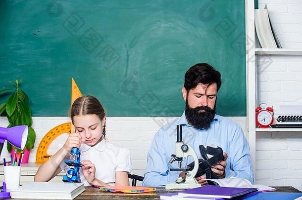 教育生物化学课。教育和知识。父亲和女儿在教室里学习。留胡子的男老师和小女孩在教室里。回到学校。数学几何。