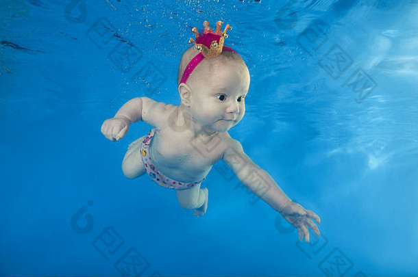 一个戴皇<strong>冠</strong>的小女孩在游泳池里游泳