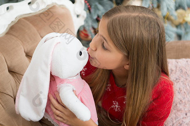 诱人的箱小女孩吻兔子玩具女孩可爱的兔子圣诞节树孩子玩软玩具小孩子快乐微笑现在圣诞节玩具