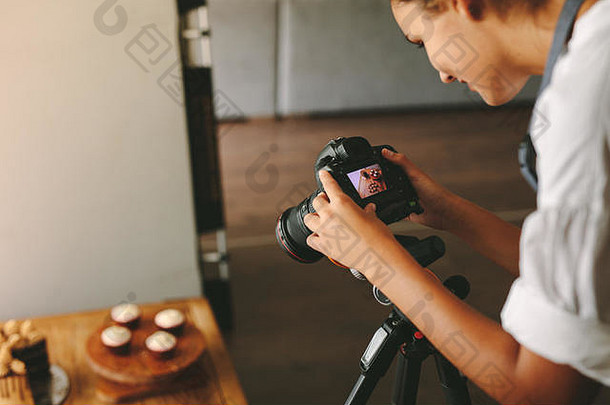 女厨师在厨房里用数码相机为她的<strong>美</strong>食博客<strong>拍照</strong>。食品摄影师用数码相机拍摄甜<strong>点</strong>的照片。