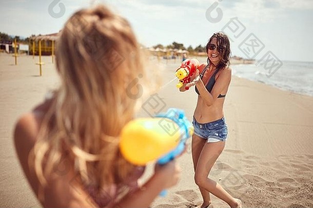 在沙滩上玩水的女孩们