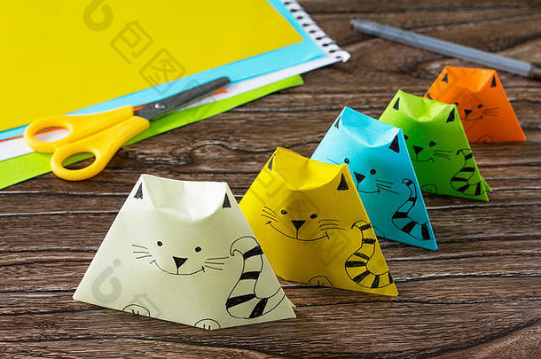 纸偶猫折纸玩具。胶水、剪刀和纸放在木桌上。儿童艺术项目儿童手工艺。儿童手艺。