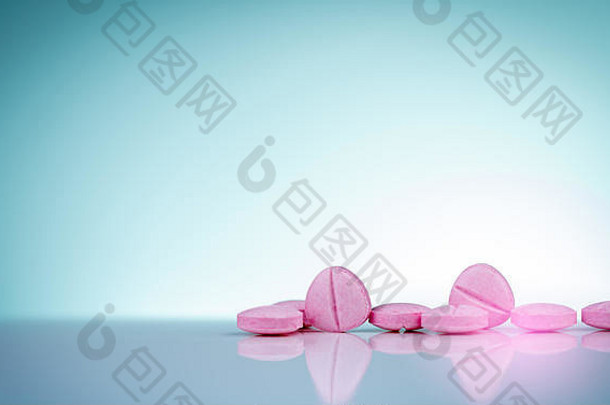 渐变背景上有阴影的粉红色药片。制药业。药品。维生素和补充剂。用药