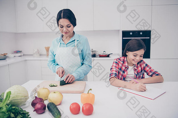 两个漂亮可爱迷人开朗活泼有梦想的人的画像妈妈做午餐健康的生活方式女孩穿着浅白做家务