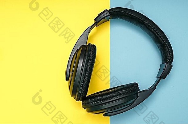 黑色大耳机位于彩色背景上。个人听音乐的设备。