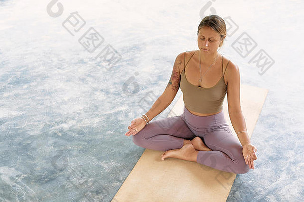 在有机垫子上练习高级瑜伽的女士。一系列瑜伽姿势。热带背景