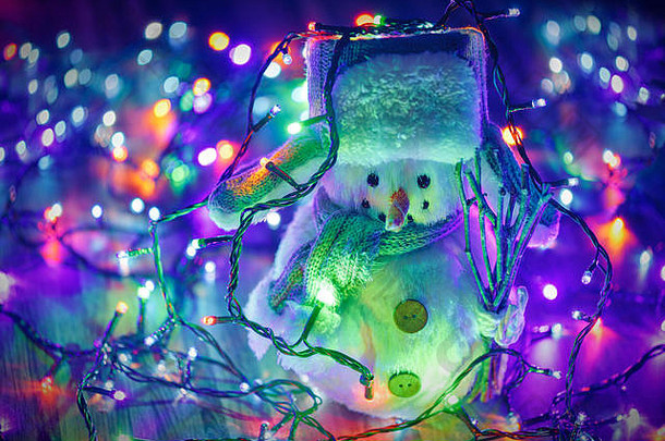 小玩具雪人色彩斑斓的圣诞节灯背景