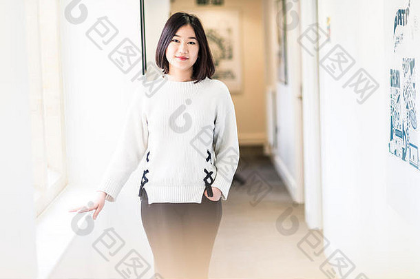 一名亚洲籍女留学生站在剑桥大学的走廊上