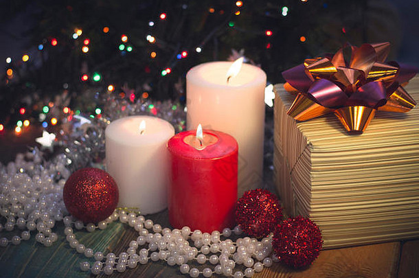燃烧着蜡烛、圣诞装饰品和礼品盒的静物画