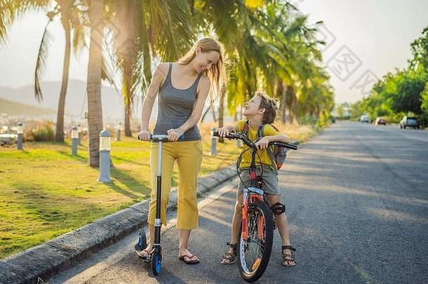 阳光明媚的日子里，孩子们和妈妈背着背包骑着<strong>自行车</strong>。快乐的孩子骑<strong>自行车</strong>上学。儿童在户外上学的安全方式