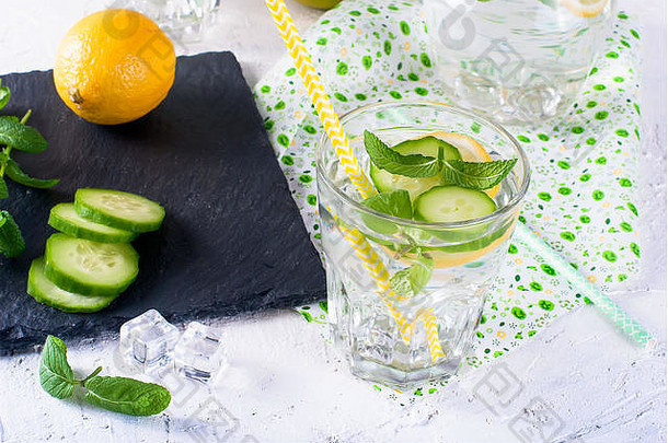 清爽的黄瓜鸡尾酒、柠檬水、解毒水装在白色背景的玻璃杯中。夏日饮料。俯视图