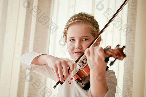 可爱的孩子（小女孩）在家拉小提琴和锻炼身体