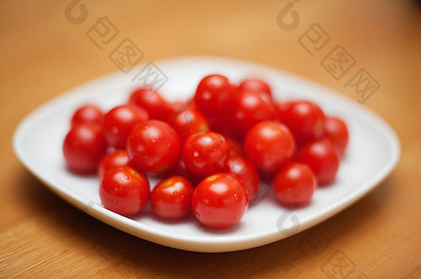 盘子里放着有机甜的红樱桃西红柿