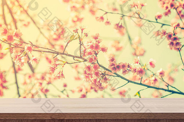 空木桌用于植入式广告或蒙太奇，粉色花朵搭配复古色调。