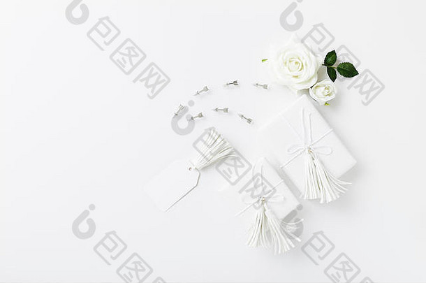 白色背景上的白色礼物和玫瑰，婚礼庆典礼物平铺